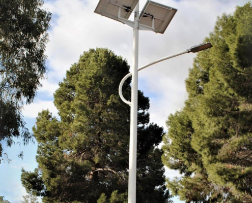 hybrid-solar-installation-1 People standing under a hybrid solar and wind powered light tower